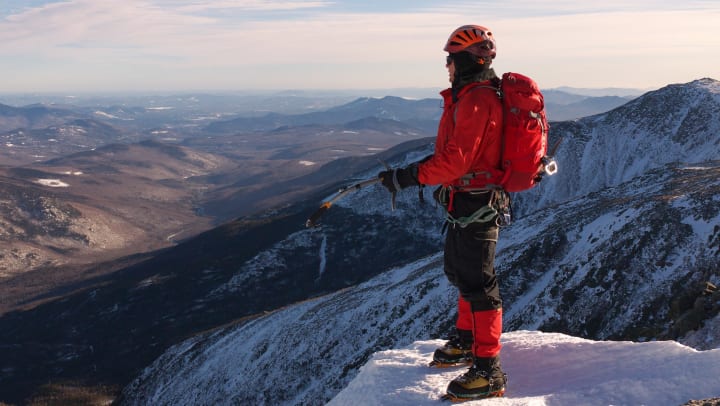 Mountain Climber summiting a snowy mountain peak