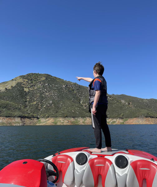 child pointing from a boat