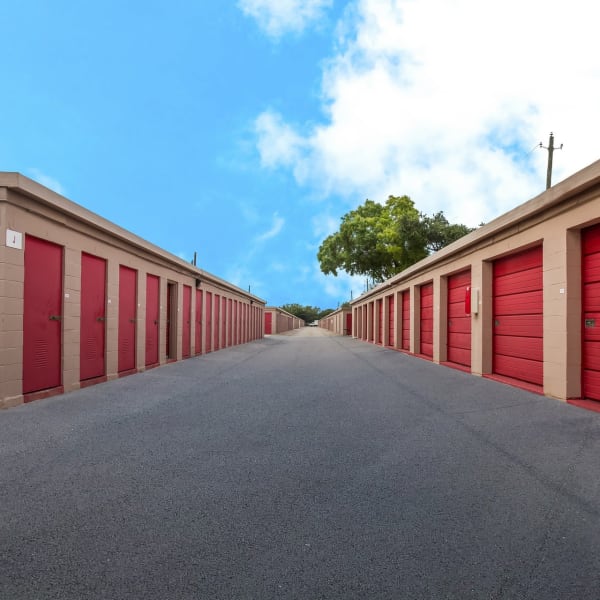 Outdoor storage units with red doors at StorQuest Self Storage in Tampa, Florida