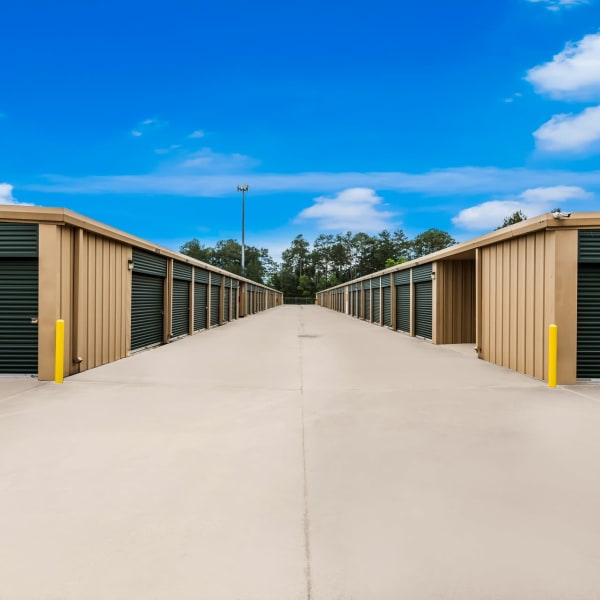 Outdoor storage units with green doors at StorQuest Self Storage in Spring, Texas