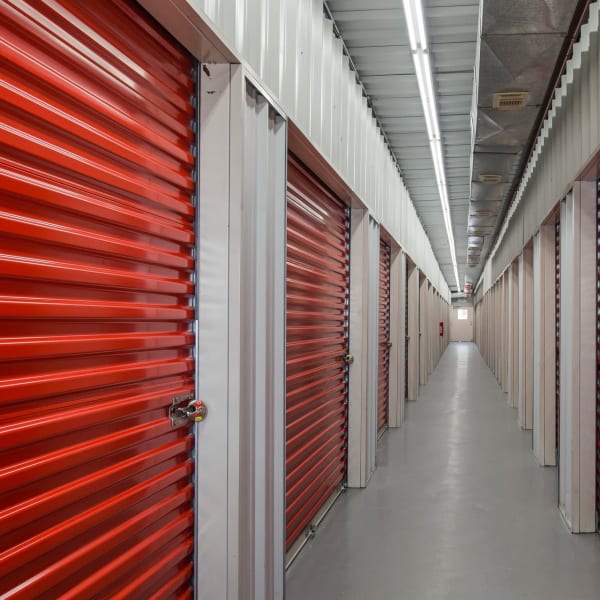 Climate-controlled storage units with red doors at StorQuest Self Storage in Friendswood, Texas